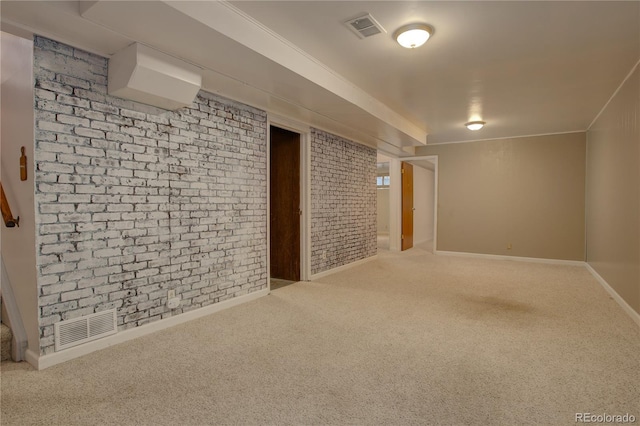 finished basement with visible vents, brick wall, baseboards, and carpet floors