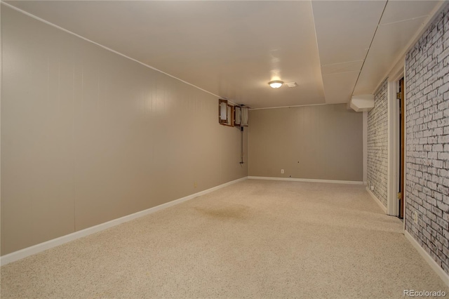 finished basement featuring carpet flooring and brick wall