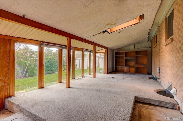 misc room with a textured ceiling, carpet, and lofted ceiling