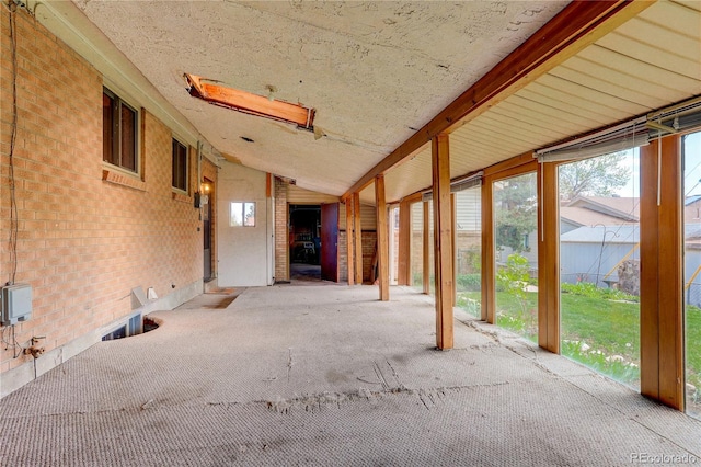 interior space featuring brick wall and lofted ceiling