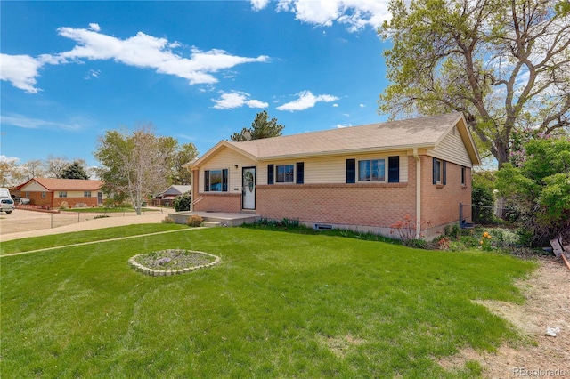 ranch-style home with a front yard, fence, and brick siding