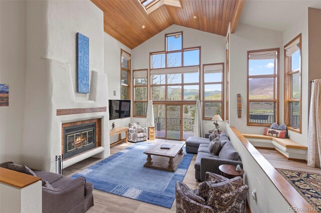 1107 Penstemon Rd, Dillon, CO 80435 - living room featuring high vaulted ceiling, a glass covered fireplace, a skylight, wooden ceiling, and wood finished floors