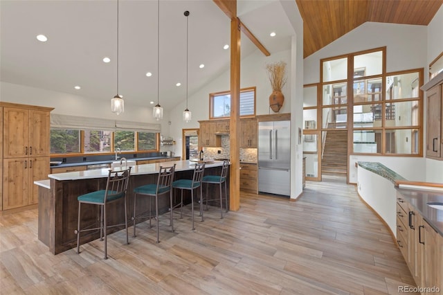 1107 Penstemon Rd, Dillon, CO 80435 - kitchen with a kitchen breakfast bar, built in fridge, light wood finished floors, a spacious island, and high vaulted ceiling