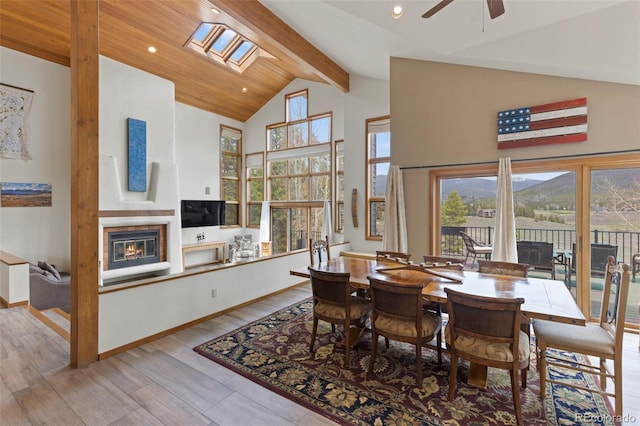 1107 Penstemon Rd, Dillon, CO 80435 - dining space with plenty of natural light, a ceiling fan, beam ceiling, wood finished floors, and a glass covered fireplace
