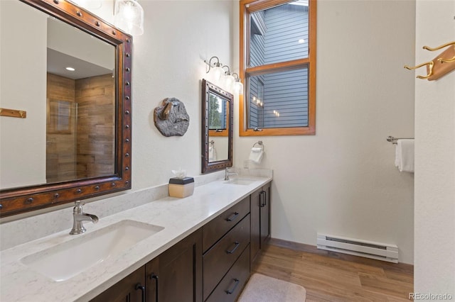 1107 Penstemon Rd, Dillon, CO 80435 - bathroom featuring baseboard heating, wood finished floors, double vanity, and a sink