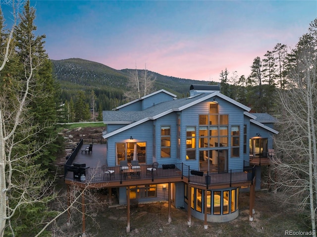 1107 Penstemon Rd, Dillon, CO 80435 - back of property at dusk with a deck with mountain view and a shingled roof