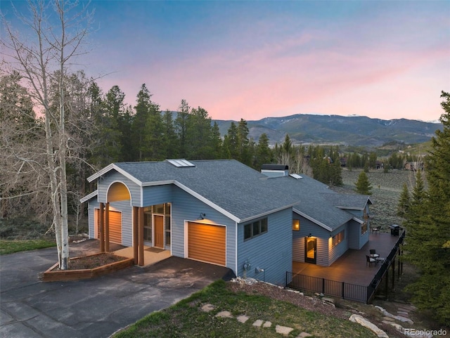 1107 Penstemon Rd, Dillon, CO 80435 - view of front facade with a mountain view, fence, an attached garage, a shingled roof, and driveway