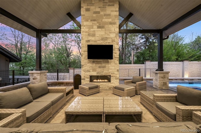 view of patio featuring fence, a fenced in pool, and an outdoor living space with a fireplace
