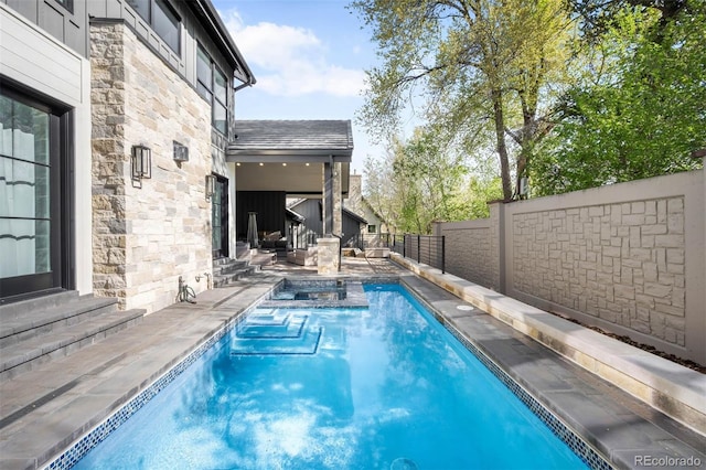 view of swimming pool featuring a fenced backyard, a fenced in pool, a jacuzzi, and a patio area