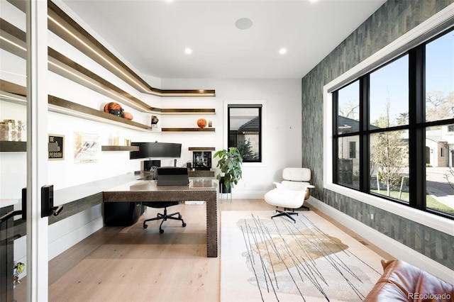 home office featuring recessed lighting, light wood finished floors, and built in desk