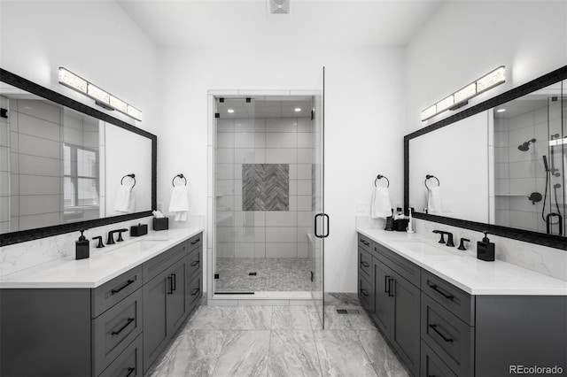 full bath with a sink, marble finish floor, two vanities, and a shower stall
