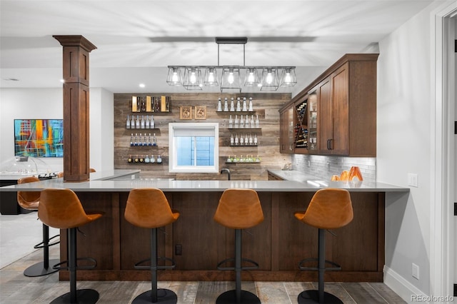 bar featuring pendant lighting, baseboards, decorative backsplash, and indoor wet bar
