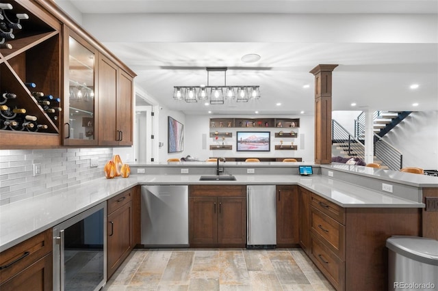 kitchen with a sink, light countertops, beverage cooler, stainless steel dishwasher, and glass insert cabinets