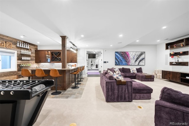 living area with indoor wet bar, decorative columns, and recessed lighting
