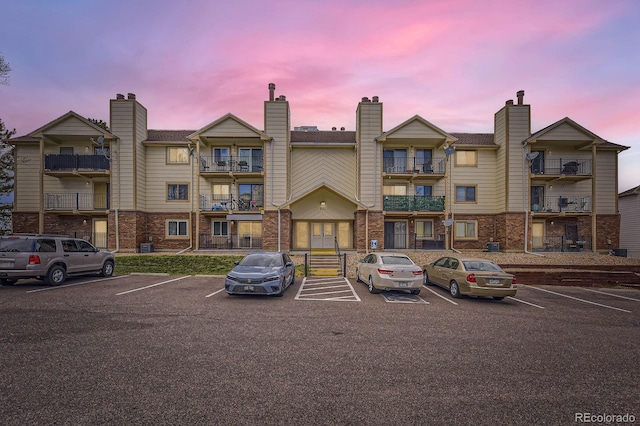 property at dusk featuring uncovered parking