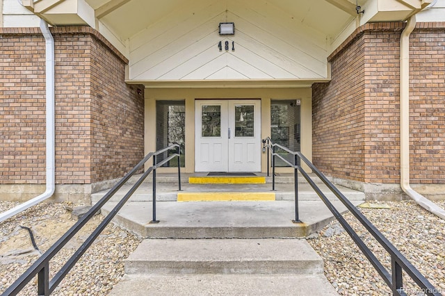 doorway to property with brick siding