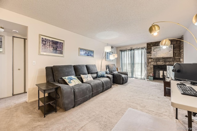 living area featuring carpet floors, a textured ceiling, and a stone fireplace
