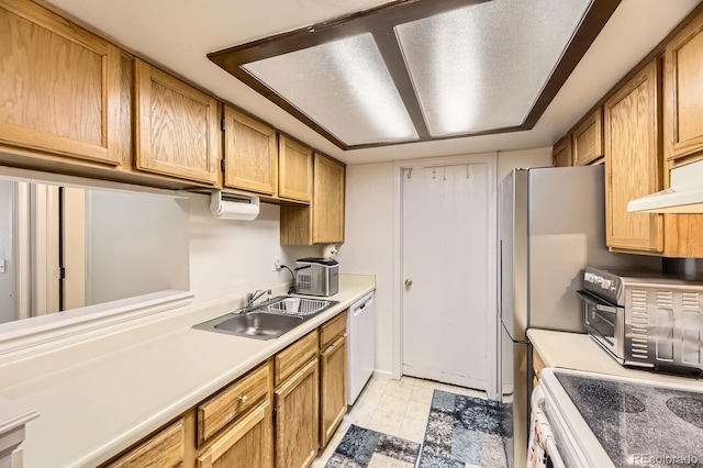 kitchen featuring brown cabinets, a sink, light countertops, light floors, and white appliances