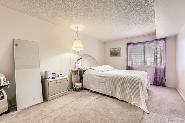 bedroom featuring light colored carpet and a textured ceiling