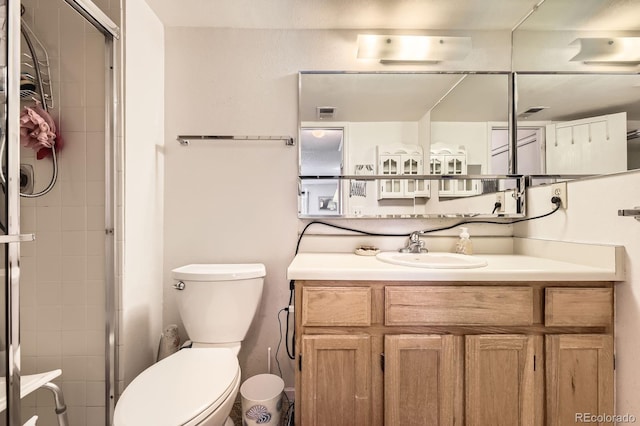 bathroom featuring vanity, a stall shower, and toilet