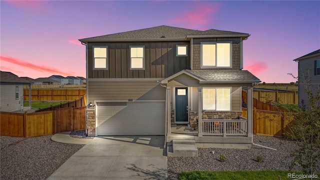 4125 Marble Dr, Longmont, CO 80504 - view of front of property featuring covered porch, concrete driveway, fence, stone siding, and an attached garage