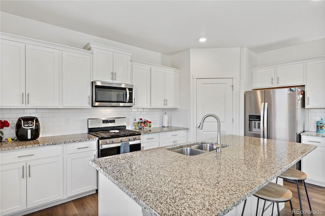 4125 Marble Dr, Longmont, CO 80504 - kitchen with stainless steel appliances, a sink, a breakfast bar, white cabinets, and recessed lighting