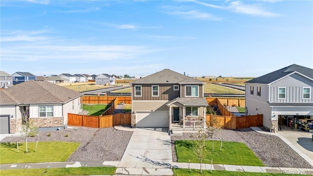 4125 Marble Dr, Longmont, CO 80504 - view of front facade with a residential view, a garage, driveway, stone siding, and board and batten siding