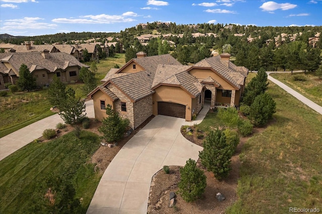 view of front of home with stucco siding, concrete driveway, a garage, a residential view, and stone siding