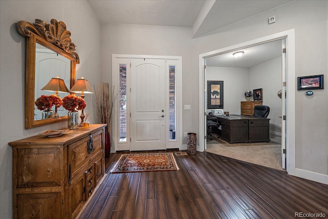 foyer with dark wood-style flooring and baseboards