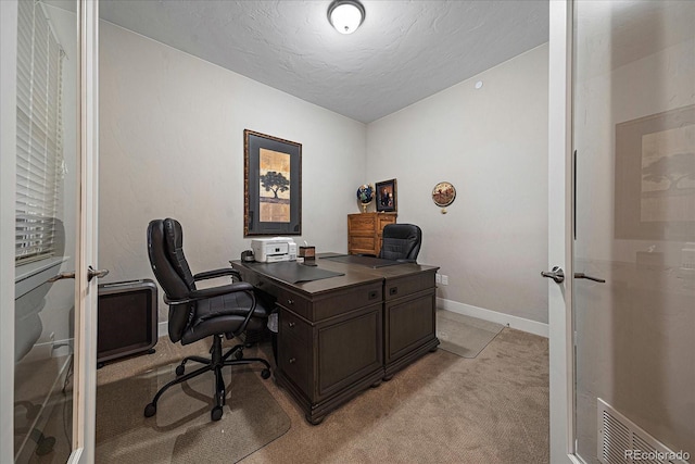 office with light colored carpet, a textured ceiling, and baseboards