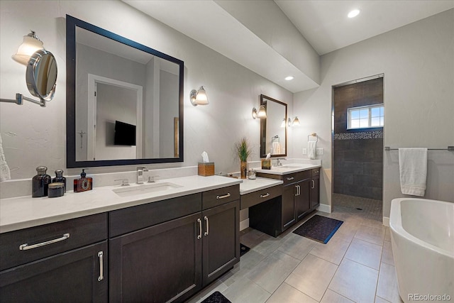 bathroom with a walk in shower, two vanities, a soaking tub, and a sink