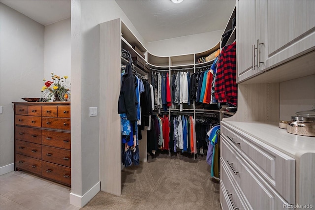 walk in closet featuring light carpet