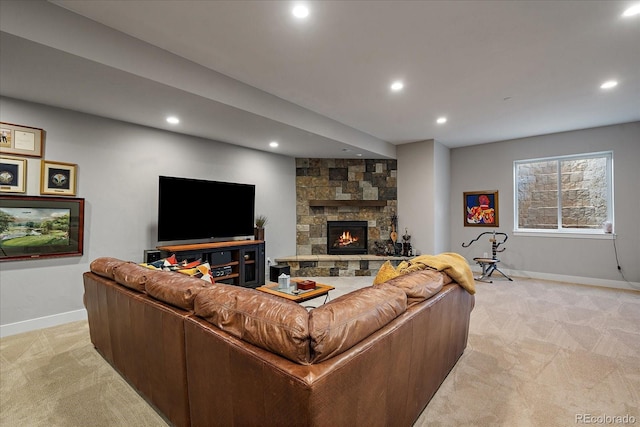 living room featuring light carpet, baseboards, a stone fireplace, and recessed lighting