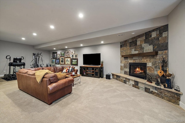 living room with light carpet, visible vents, a stone fireplace, and recessed lighting