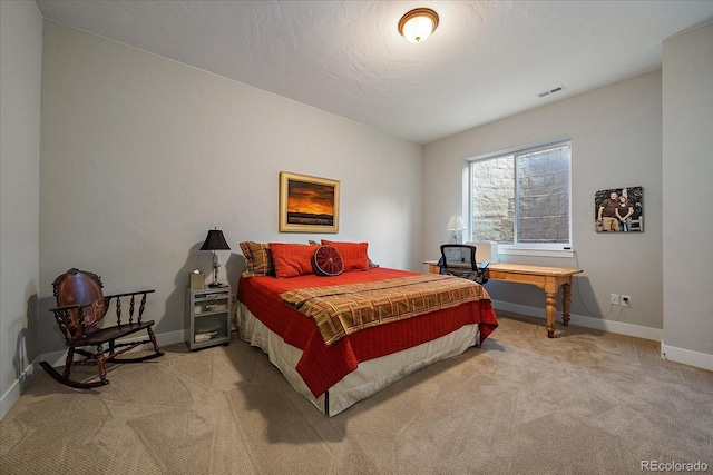 bedroom with carpet floors, visible vents, a textured ceiling, and baseboards