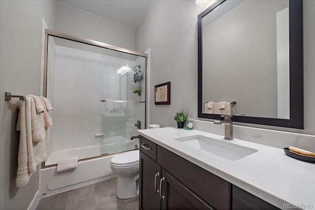 full bathroom featuring enclosed tub / shower combo, vanity, tile patterned flooring, and toilet