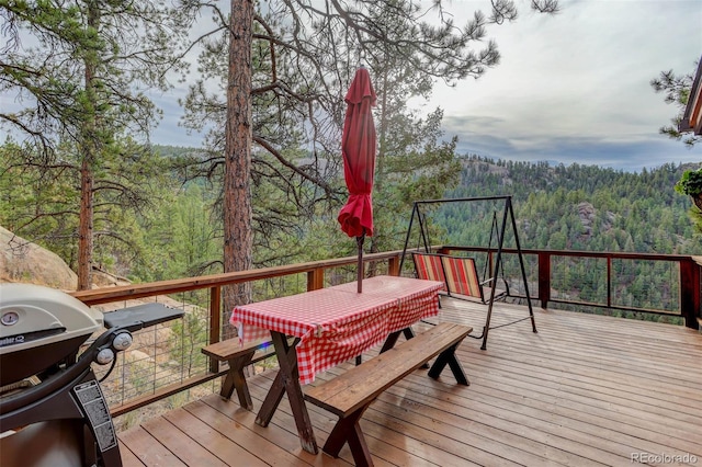 16048 Old Stagecoach Rd, Pine, CO 80470 - wooden terrace with a wooded view, outdoor dining area, and grilling area