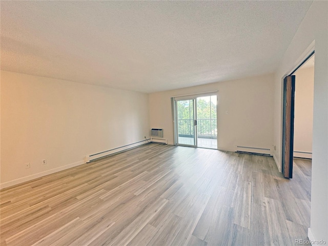 unfurnished room featuring a textured ceiling, baseboard heating, and light hardwood / wood-style flooring