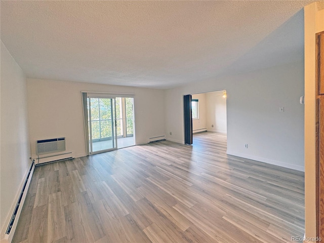 unfurnished room featuring a textured ceiling, light hardwood / wood-style flooring, and a baseboard heating unit