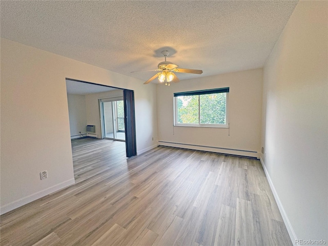 empty room featuring ceiling fan, light wood-type flooring, plenty of natural light, and baseboard heating