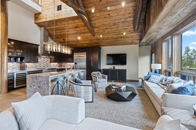 living room featuring light hardwood / wood-style floors, beam ceiling, high vaulted ceiling, and wooden ceiling