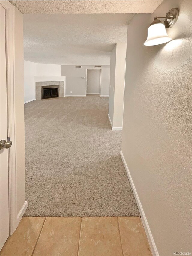 corridor with a textured ceiling and carpet flooring