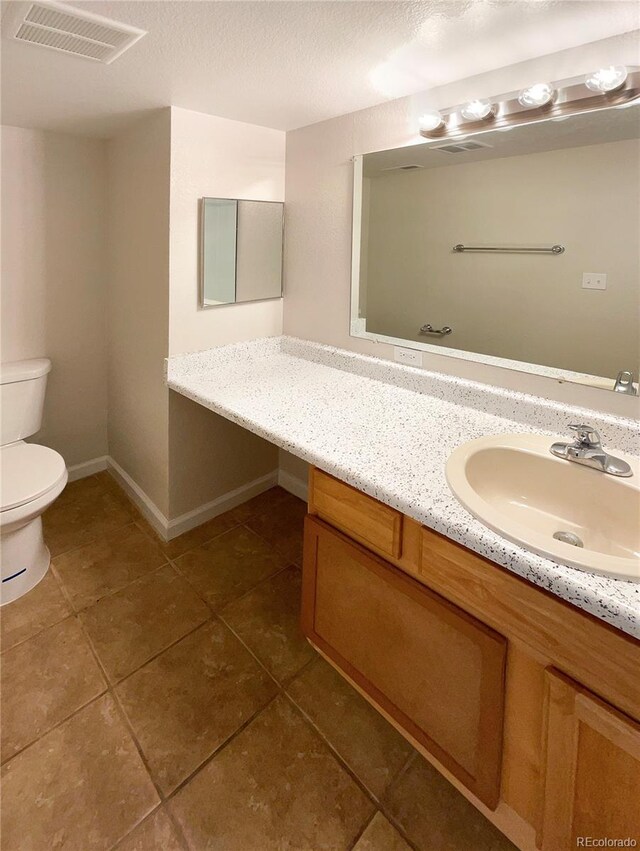 bathroom with vanity, toilet, and tile patterned floors