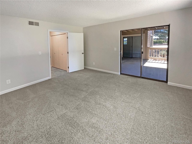 spare room with light carpet and a textured ceiling