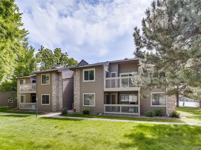 exterior space featuring a balcony and a lawn