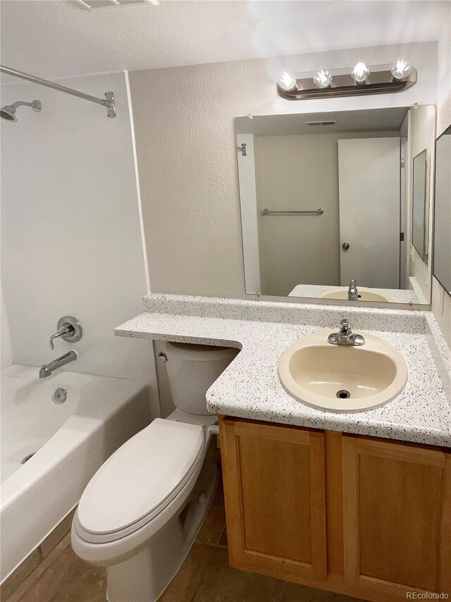 full bathroom with tile patterned flooring, vanity, toilet, and  shower combination