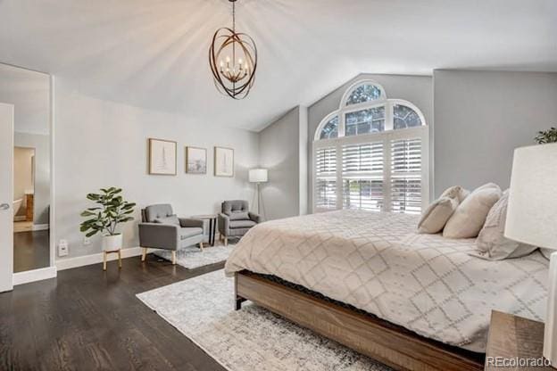 bedroom with lofted ceiling, a chandelier, wood finished floors, and baseboards