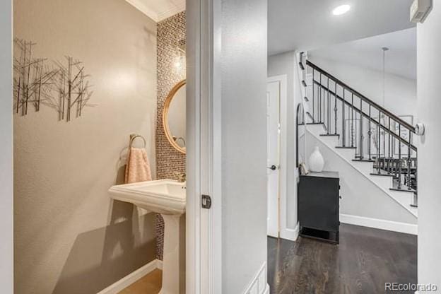 stairs with wood finished floors, baseboards, and recessed lighting