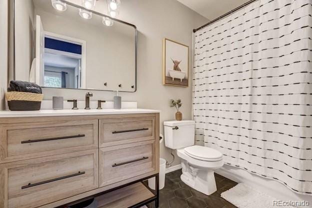 bathroom with toilet, vanity, tile patterned floors, and curtained shower