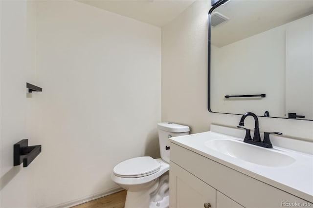 bathroom featuring wood-type flooring, vanity, and toilet